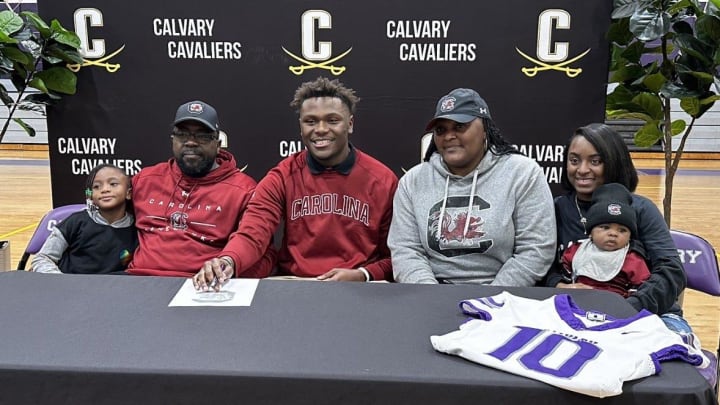 Michael Smith of Calvary Day, pictured with his family, signed to play football at South Carolina in a ceremony at the Calvary campus.