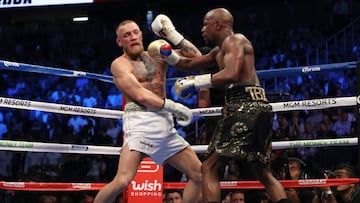 LAS VEGAS, NV - AUGUST 26: (R-L) Floyd Mayweather Jr. throws a punch at Conor McGregor during their super welterweight boxing match on August 26, 2017 at T-Mobile Arena in Las Vegas, Nevada.   Christian Petersen/Getty Images/AFP == FOR NEWSPAPERS, INTERN